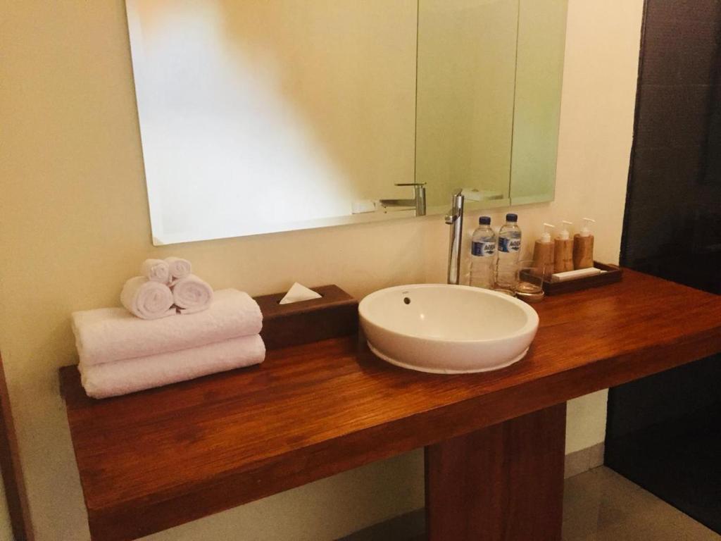 a bathroom counter with a sink and a mirror at The Tinsi in Nusa Penida