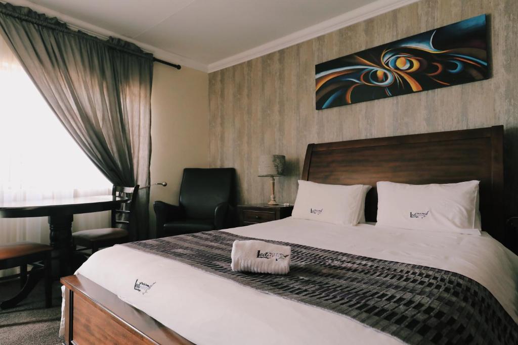 1 dormitorio con cama, escritorio y silla en Ledumo Guest lodge en Witbank