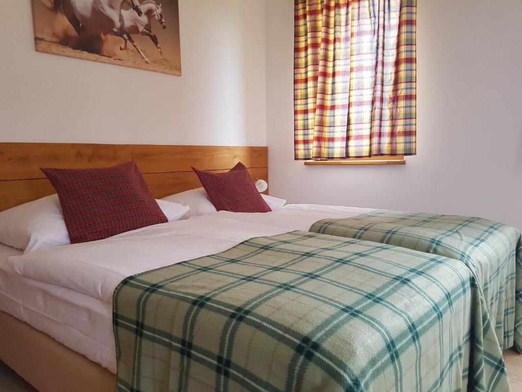 Un dormitorio con una cama con una manta a cuadros. en BIO Farma & Penzión Zlatý Hýľ, en Nováčany
