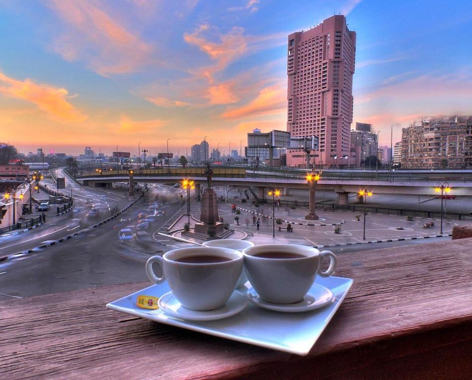 duas chávenas de café numa mesa com vista para uma cidade em Tahrir Plaza Suites - Museum View em Cairo
