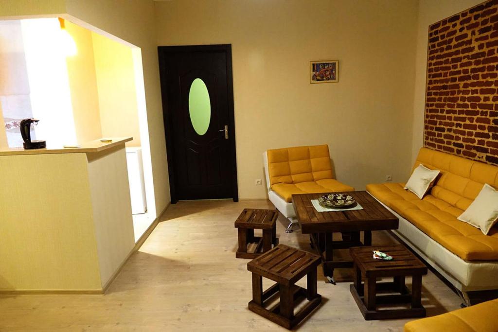 Una sala de estar con un sofá y una mesa y una puerta. en Apartment Vorontsov, en Tiflis