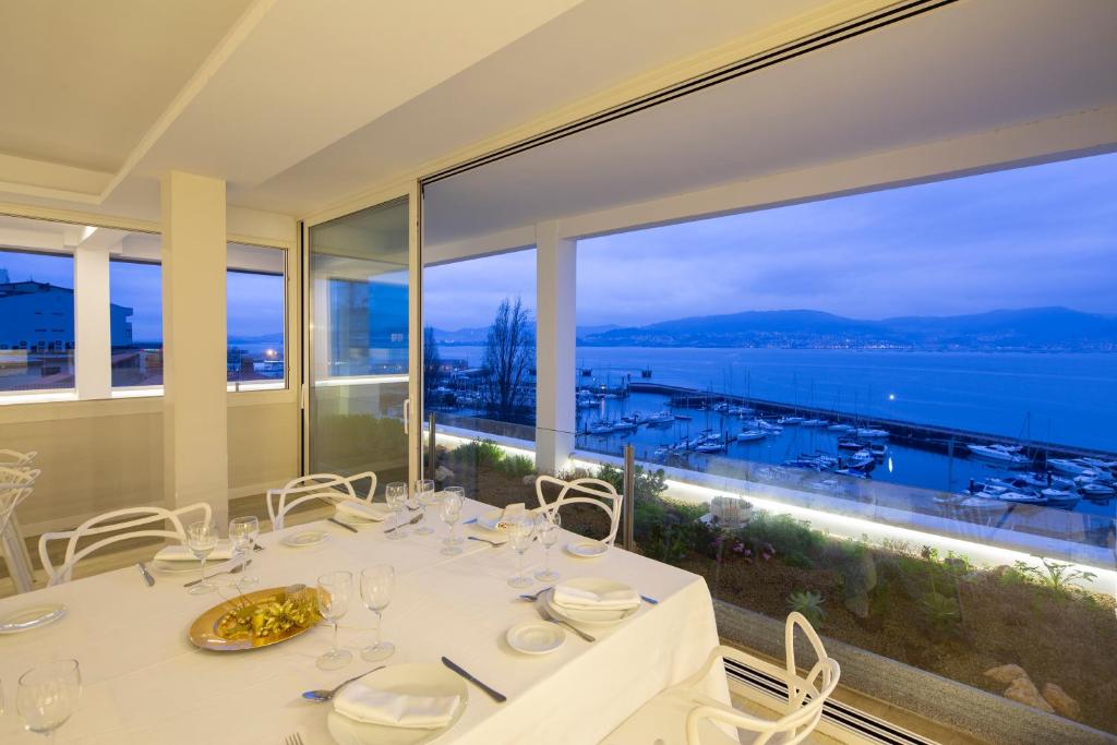 a dining room table with a view of the ocean at Hotel Ciudad de Vigo in Vigo
