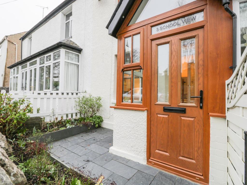 a wooden front door of a white house at 3 School View in Ulverston