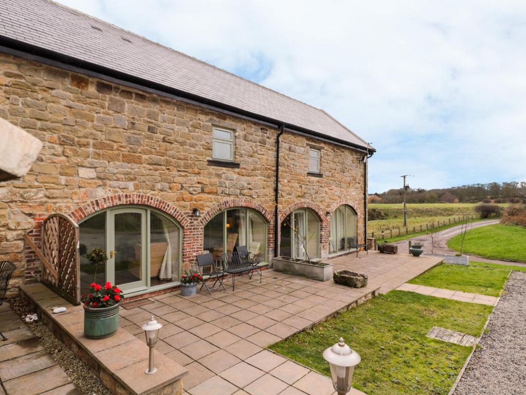 a brick house with a patio in front of it at Granary Barn in Gateshead