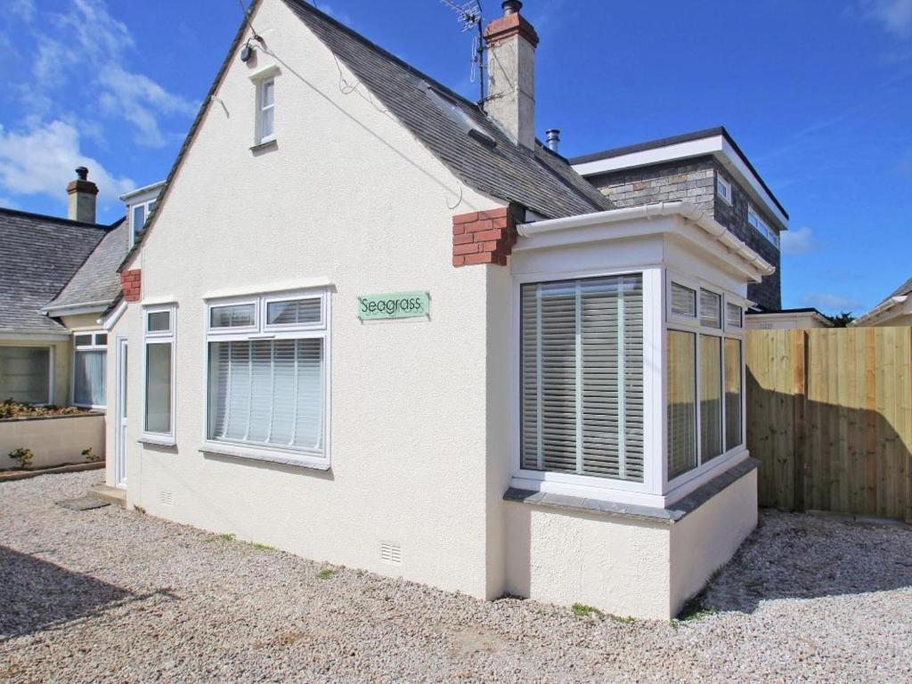 a white house with a fence in front of it at Seagrass in Newquay