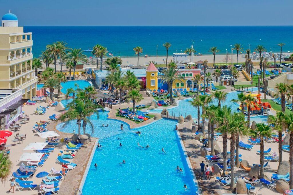
a beach filled with lots of colorful umbrellas at Mediterraneo Bay Hotel & Resort in Roquetas de Mar
