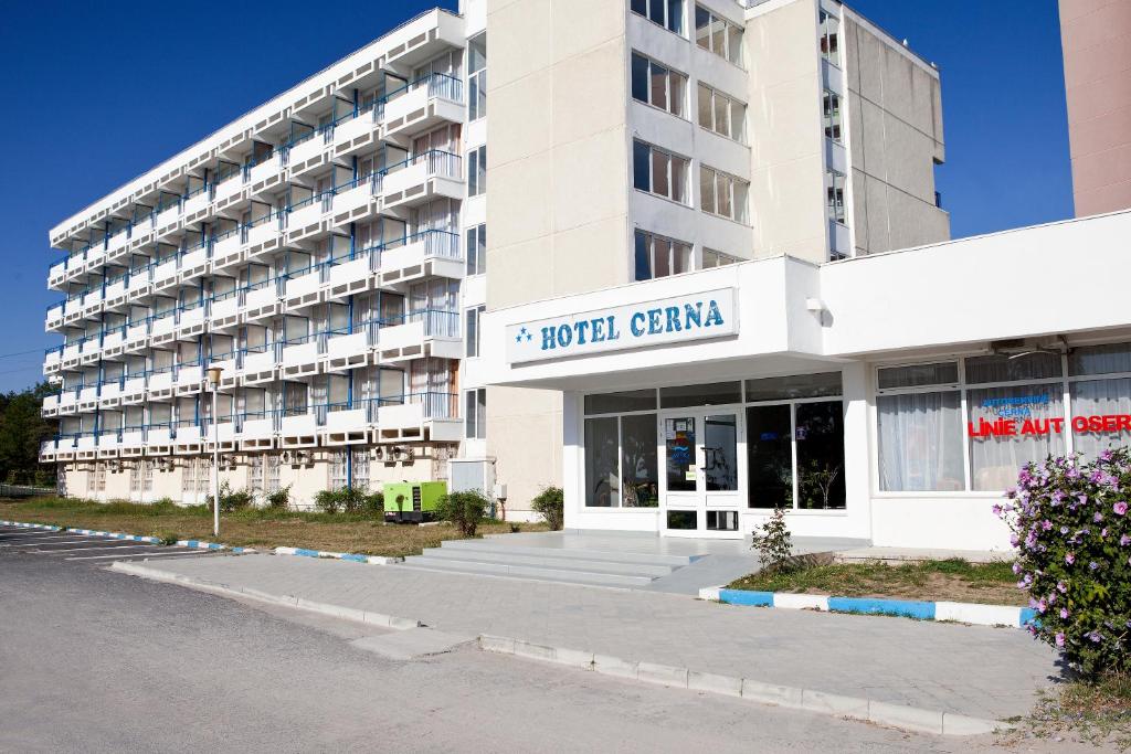 un gran edificio blanco con una señal para un centro hotelero en Hotel Cerna, en Saturn