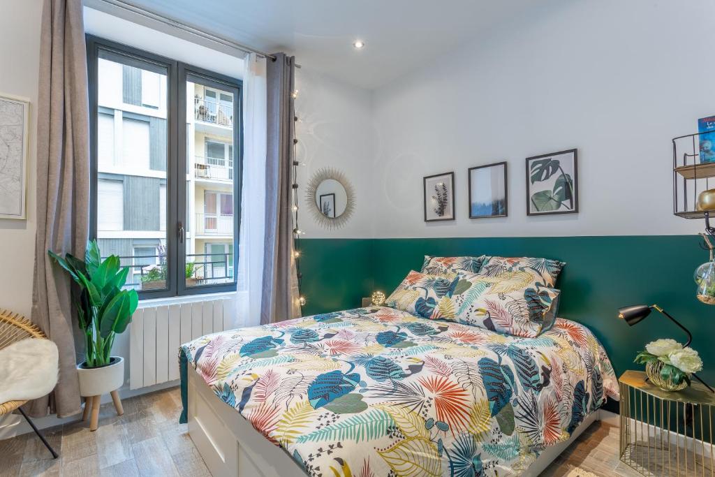 um quarto com uma cama e uma janela em Les Cocons Emeraude et Fleuri em Lyon