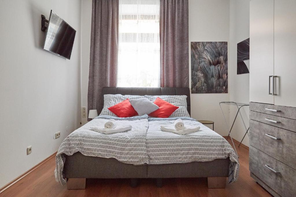 a bedroom with a bed with red pillows and a window at Modern Apartment suitable for Longstays in Vienna