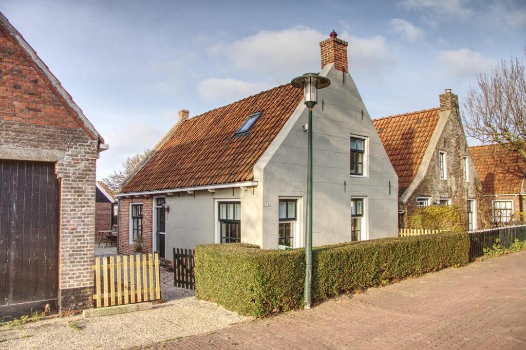 une maison blanche avec un toit marron dans l'établissement Huisje de Eersteling, à Moddergat