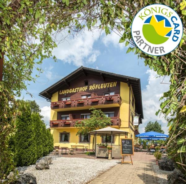 a yellow building with a sign in front of it at Landhotel Röfleuten in Pfronten