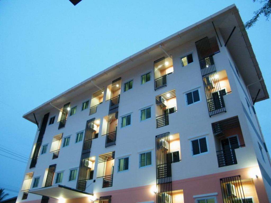 um grande edifício branco com janelas à noite em Fundee 1 Mansion em Ubon Ratchathani