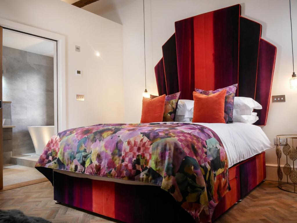 a bedroom with a large bed with a colorful bedspread at Padstow Escapes - The Long Room Luxury Apartment in Padstow