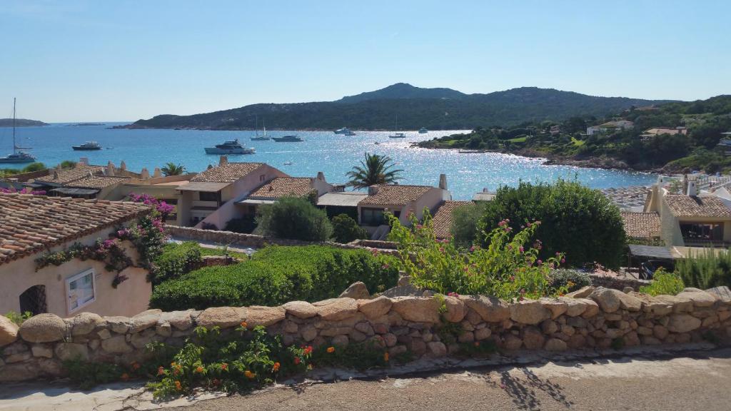 a town with a stone wall in front of the water at Inter-Résidences Costa Smeralda in Porto Cervo