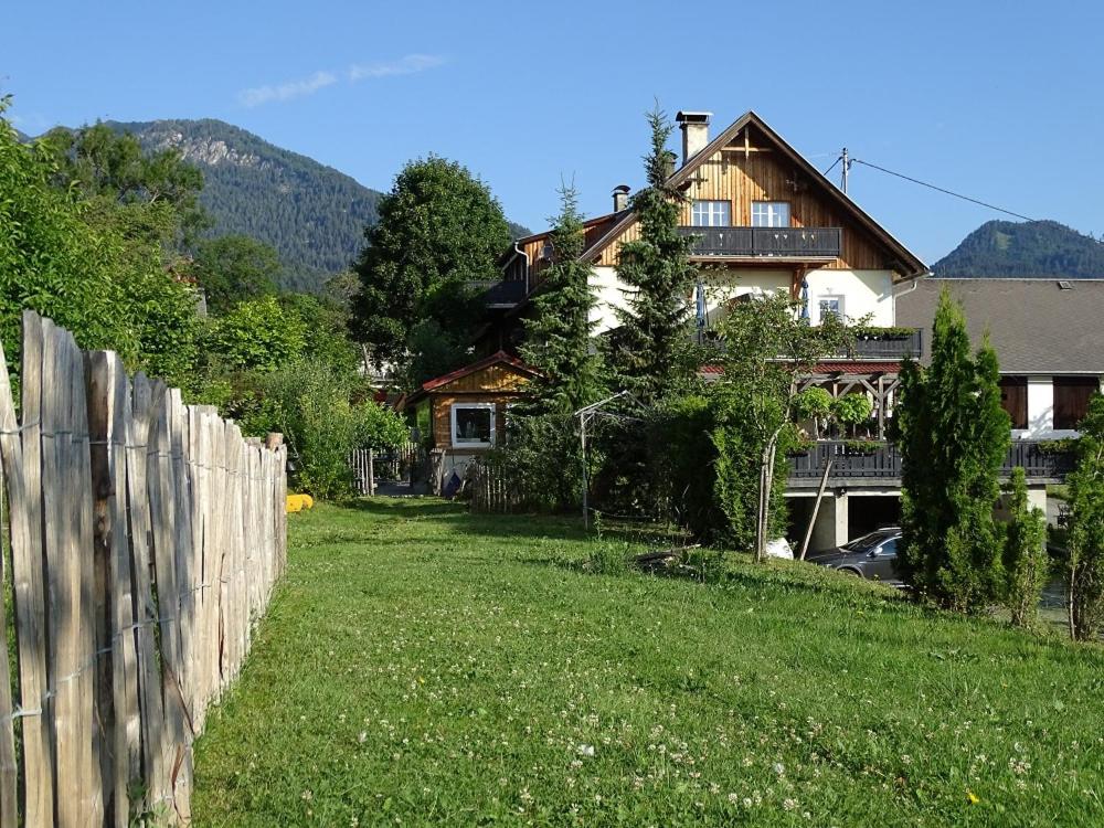 a yard with a fence and a house at B&B Landhof Schober in Weissbriach