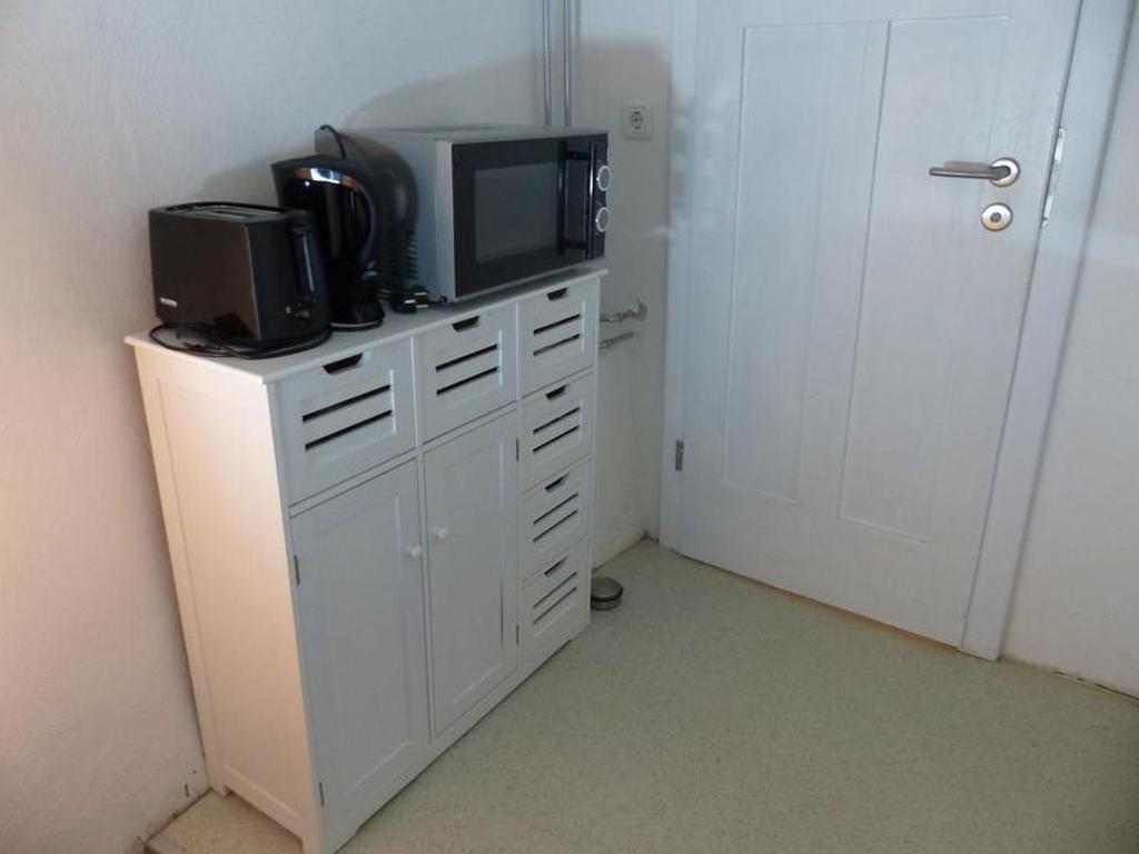 a white cabinet with a microwave and a television on it at Ferienwohnungen Homberger Altstadt in Homberg