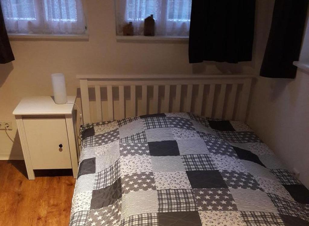 a bedroom with a bed with a checkered quilt at Ferienwohnungen Homberger Altstadt in Homberg