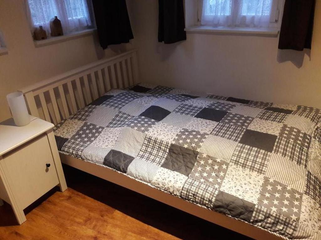 a bedroom with a bed with a checkered blanket on it at Ferienwohnungen Homberger Altstadt in Homberg