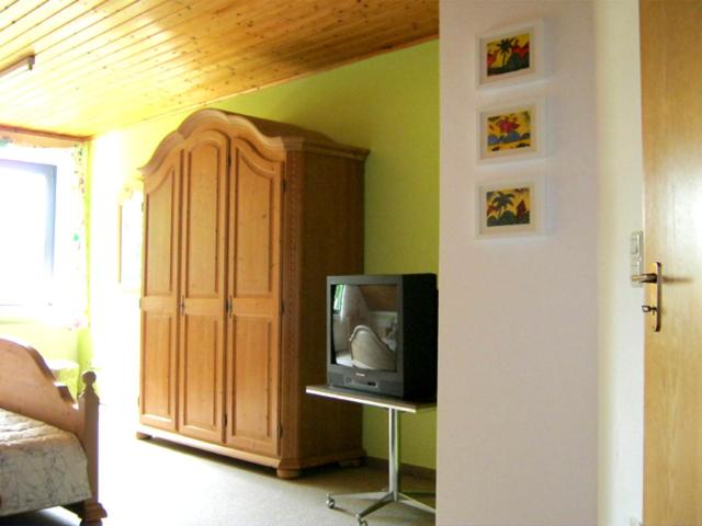 Ferienwohnung Lohberg في Raesfeld: غرفة معيشة مع تلفزيون وخزانة
