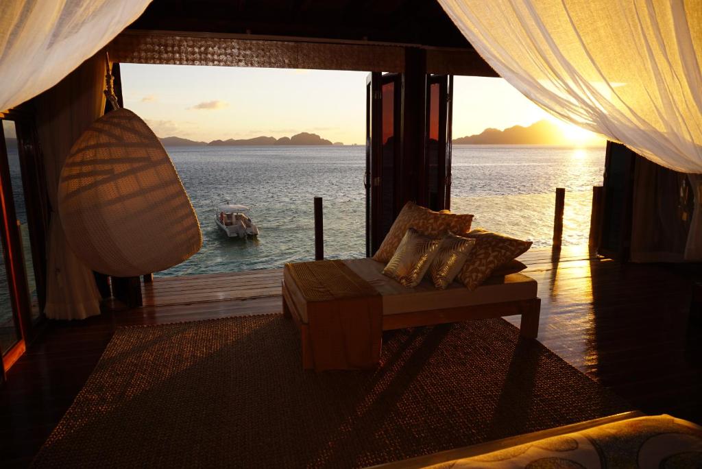 エルニドにあるヴェラゴ リゾートのソファ付きの客室で、水辺の景色を望めます。