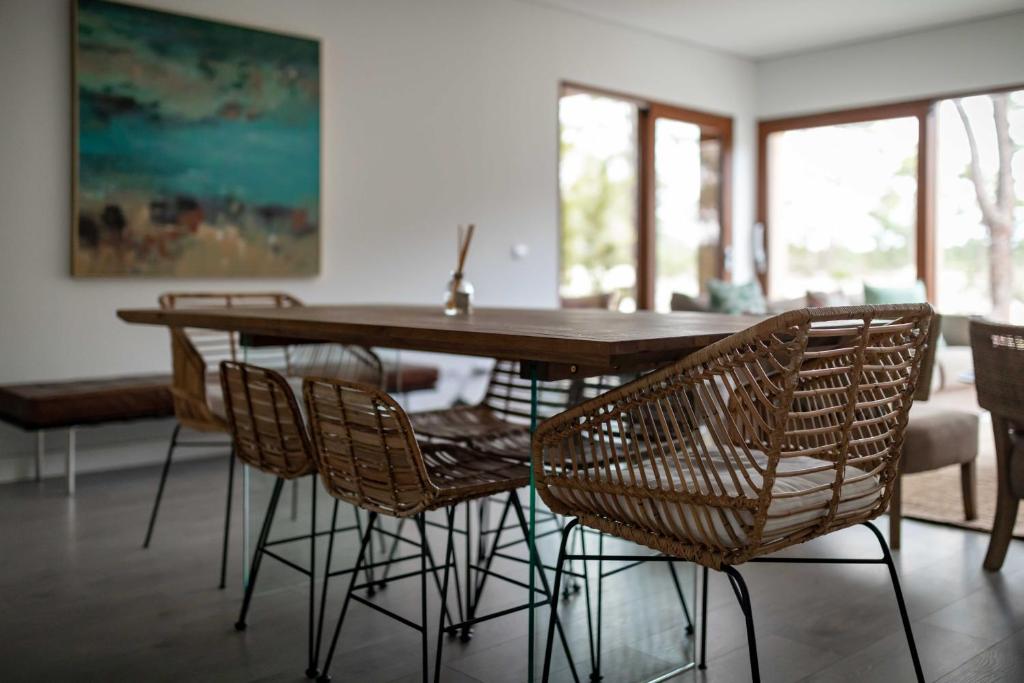 a dining room with a wooden table and chairs at Pestana Troia Eco-Resort & Residences in Troia