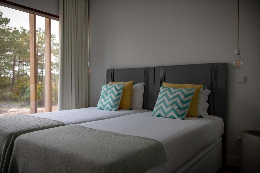 two beds sitting next to a window in a bedroom at Pestana Troia Eco-Resort & Residences in Troia