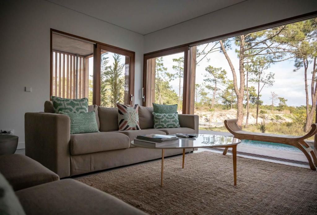 a living room with a couch and a glass table at Pestana Troia Eco-Resort & Residences in Troia