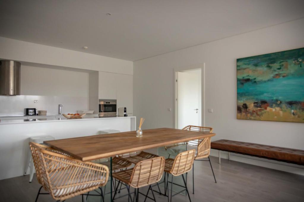 a dining room with a wooden table and chairs at Pestana Troia Eco-Resort & Residences in Troia