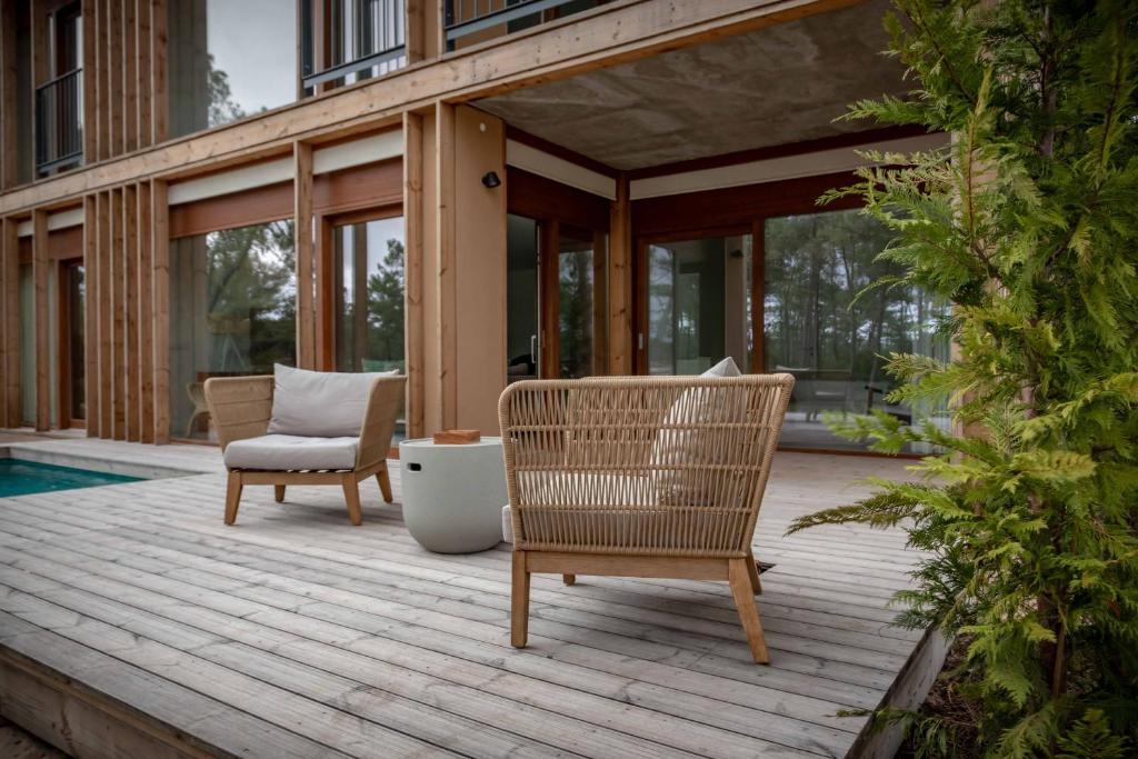a wooden deck with two chairs and a couch at Pestana Troia Eco-Resort & Residences in Troia