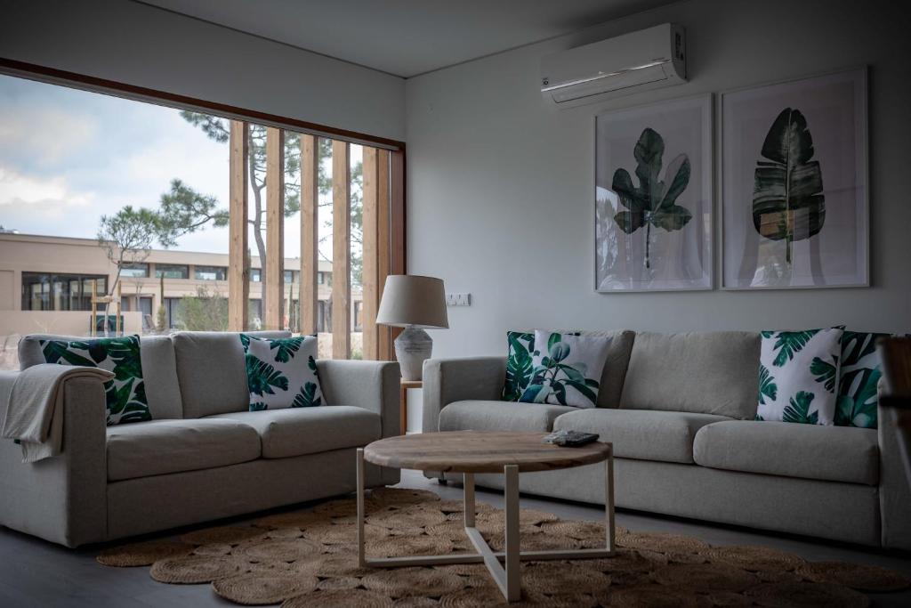 a living room with a couch and a coffee table at Pestana Troia Eco-Resort & Residences in Troia