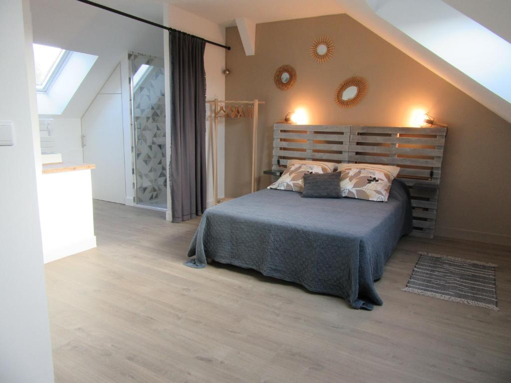 um quarto com uma cama e uma cabeceira em madeira em Les Bordes em Vineuil