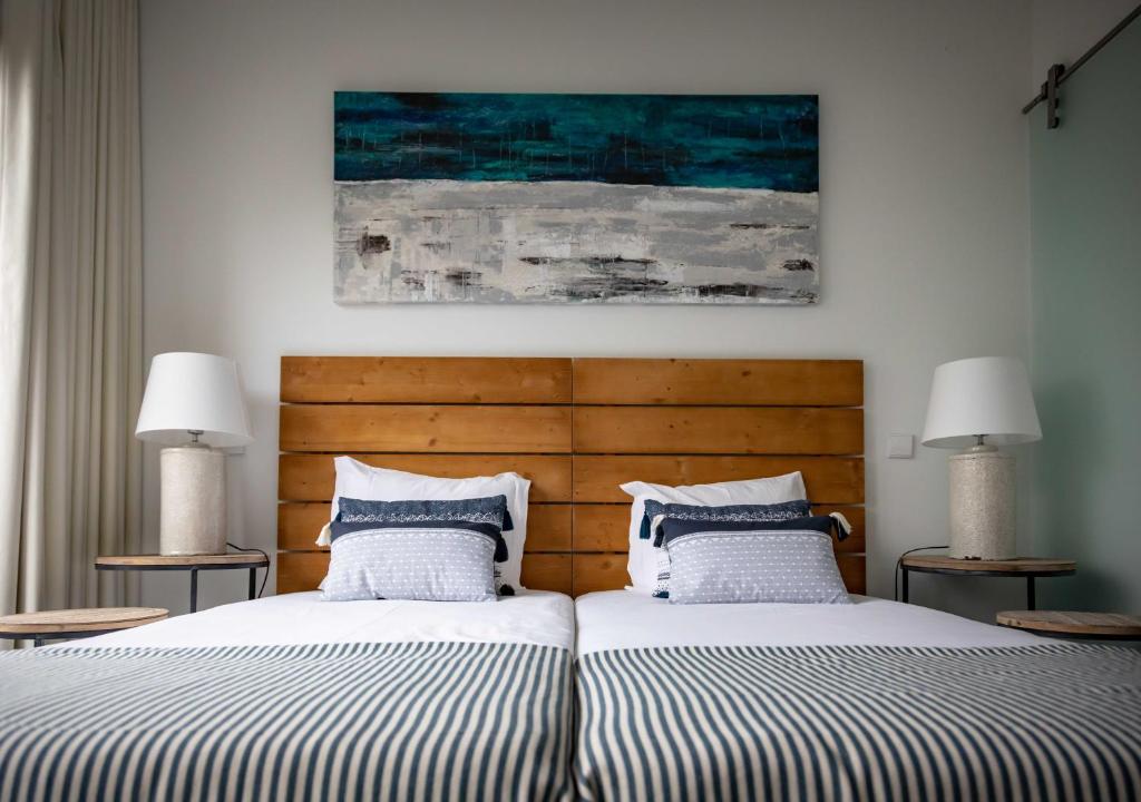 two beds sitting next to each other in a bedroom at Pestana Troia Eco-Resort & Residences in Troia