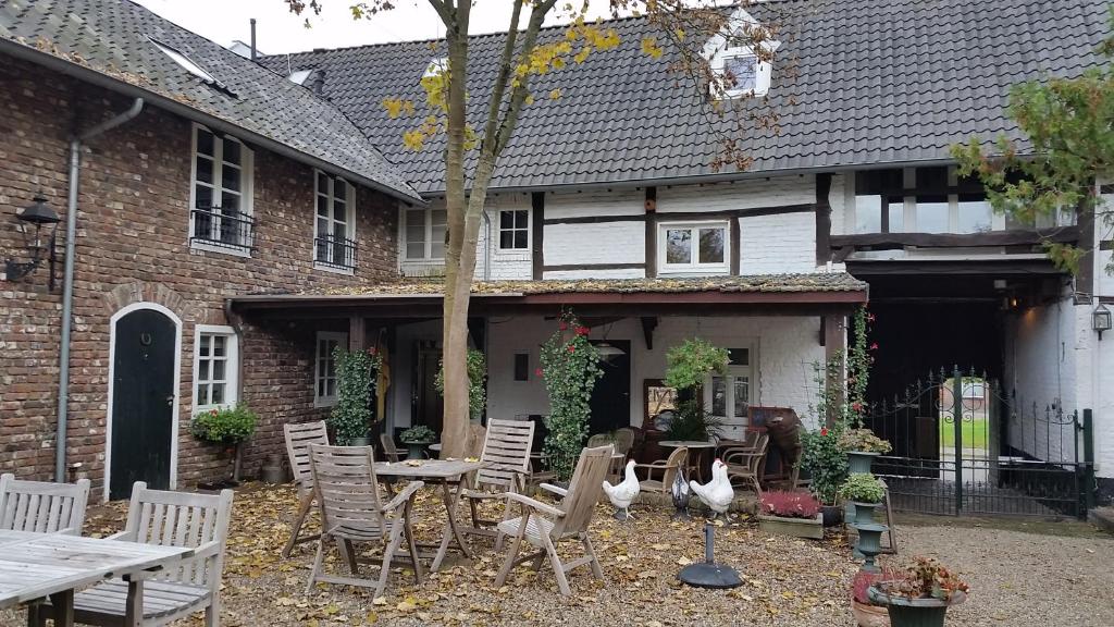 een patio met stoelen en een tafel en een huis bij apartements Stegelshof in Eygelshoven