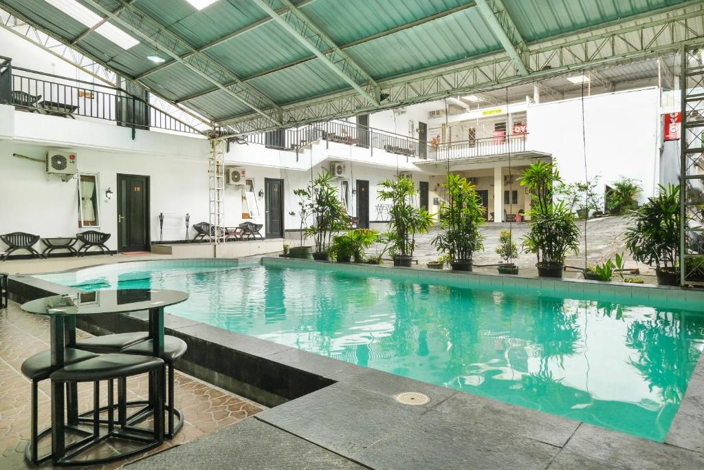 a large swimming pool with a table in the middle at SUPER OYO 409 Pondok Helomi in Yogyakarta