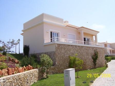 a large white house with a stone wall at 12 A Clube Golfemar in Carvoeiro