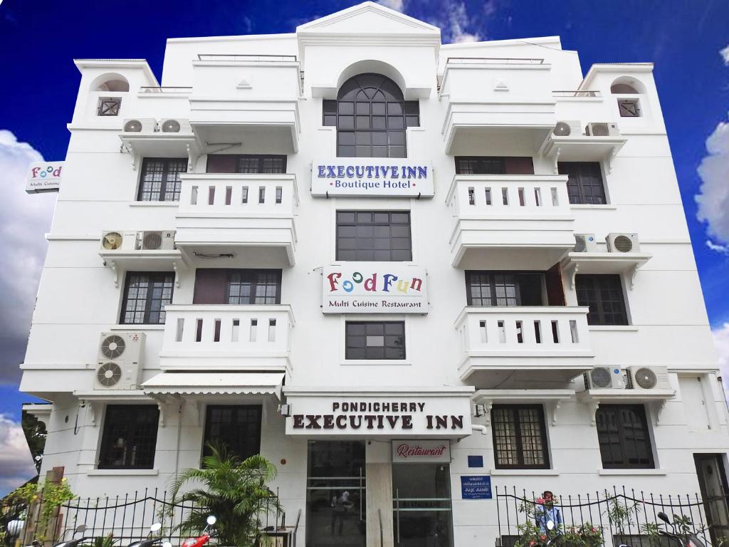 a white building with a sign on it at Pondicherry Executive Inn in Pondicherry