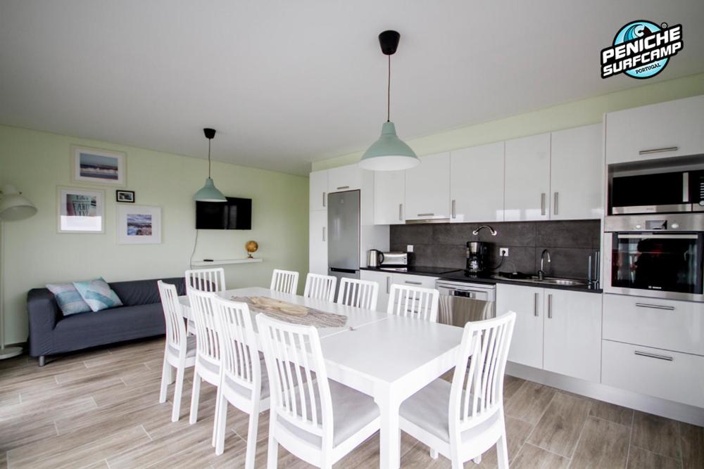 Una cocina y un comedor con una mesa y sillas blancas. en Ocean Two & Three Room Apartments, en Peniche