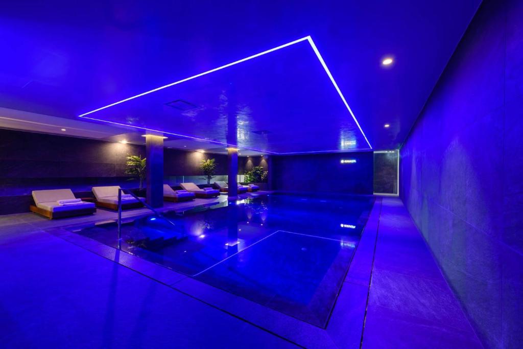 a large swimming pool in a house with purple lights at Ajax Hotel in Limassol