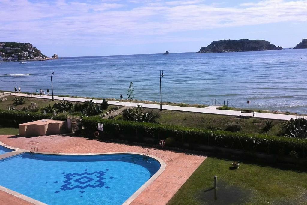 una piscina junto a un cuerpo de agua en L´Estartit, estudio en primera linea de mar., en L'Estartit