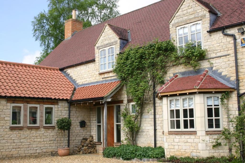 a brick house with a red roof at The Swallows Rest Bed & Breakfast in Brigstock