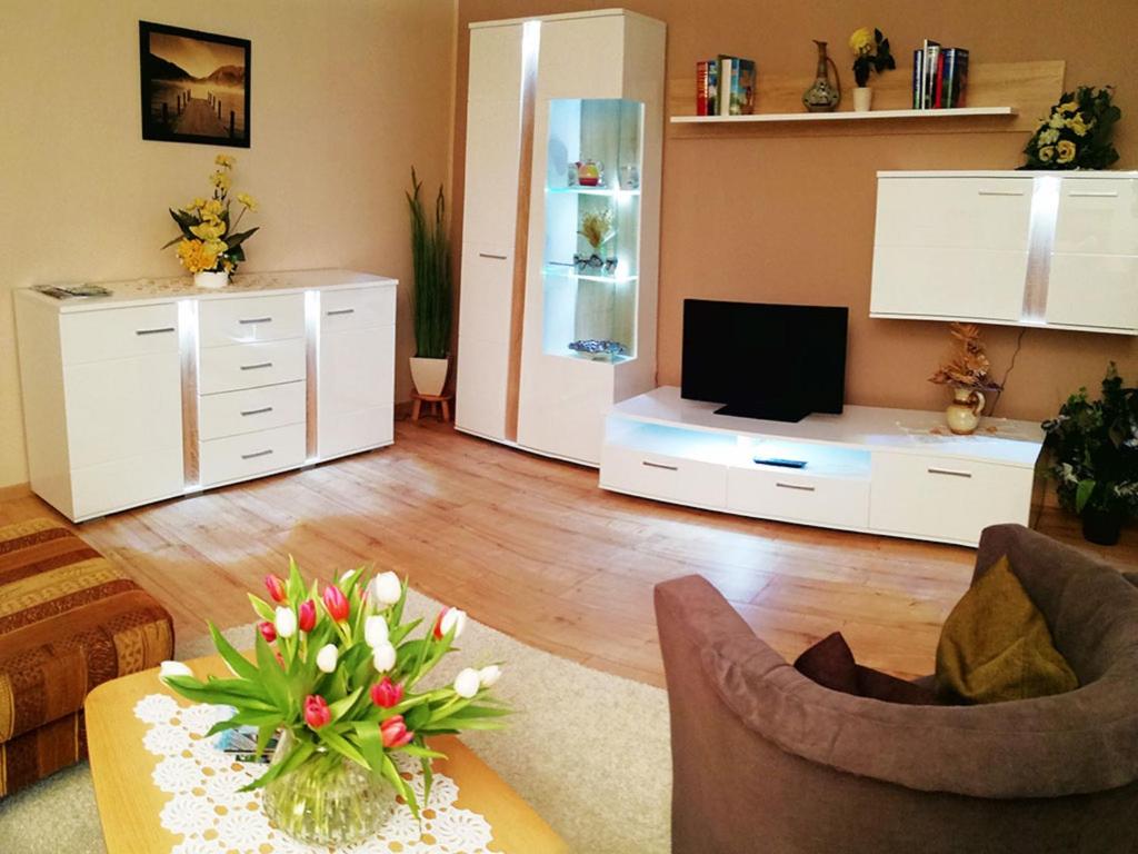 ein Wohnzimmer mit Sofa und Fernseher in der Unterkunft Ferienwohnung Christian in Bad Birnbach