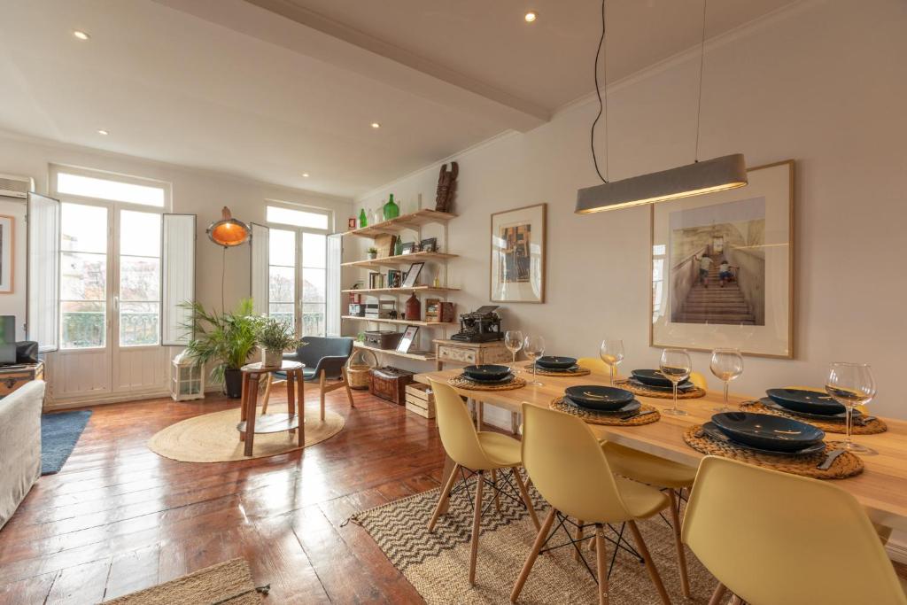 a living room with a large wooden table and chairs at Fantastic Family Apartment in Estrela in Lisbon