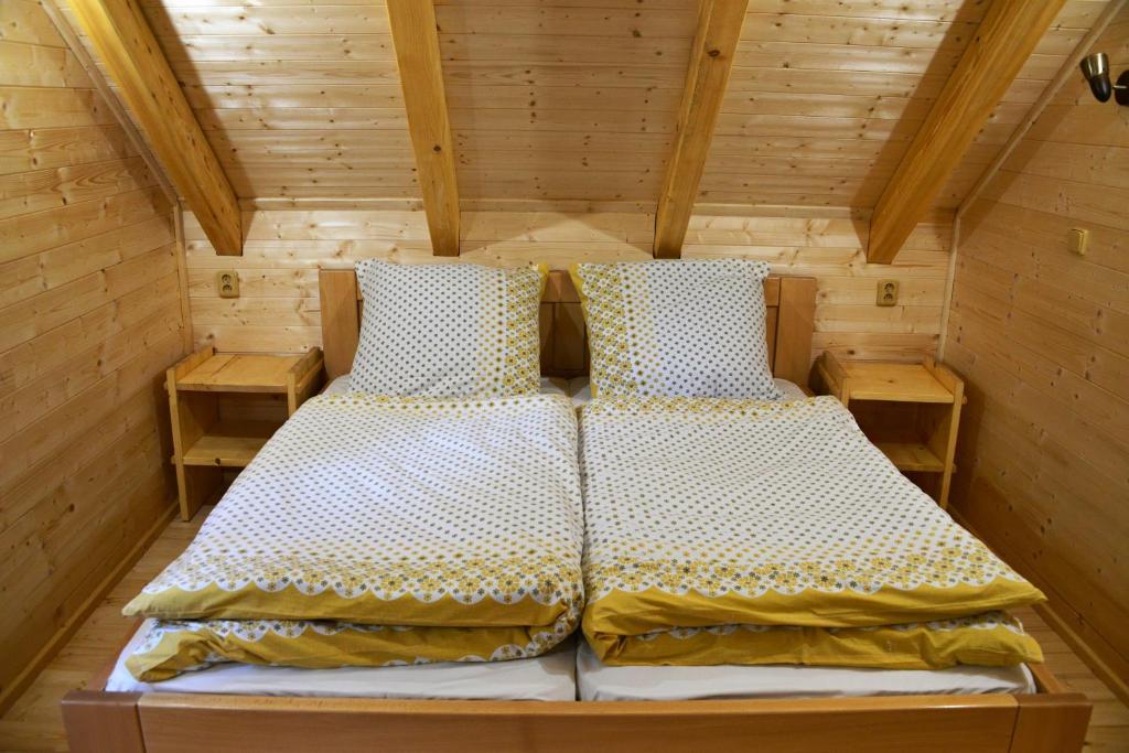 a bedroom with a bed in a wooden room at Roubenka rekreační středisko Vápenky in Nová Lhota