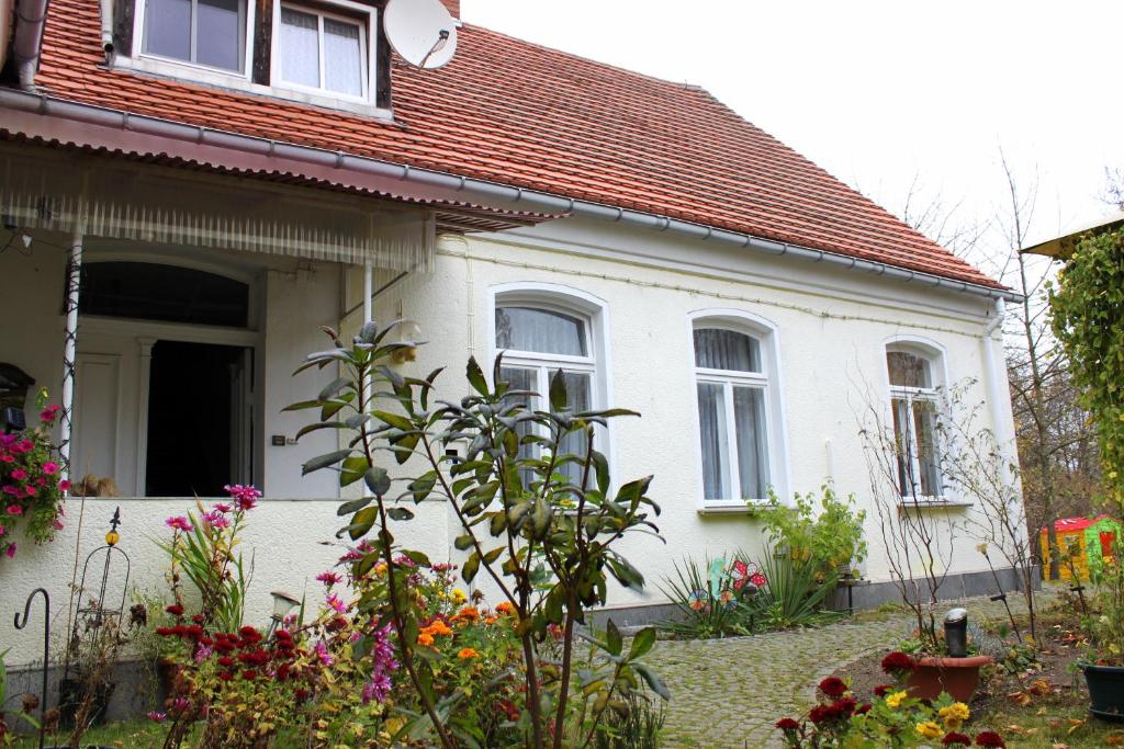una casa blanca con flores delante en Wellness-Suiten Neuburxdorf, en Neuburxdorf
