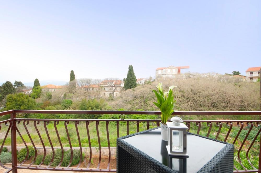 un tavolo su un balcone con vista di Apartments Omo 1 a Supetar (San Pietro di Brazza)
