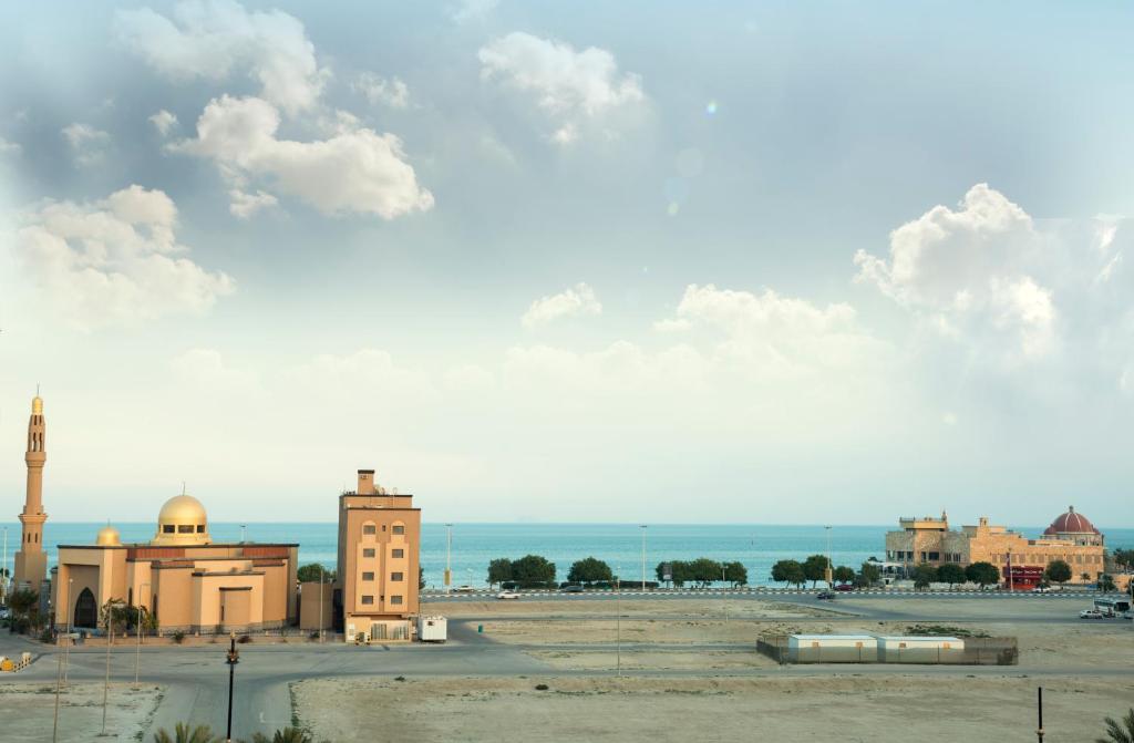 einen Blick auf eine Stadt mit einer Moschee und das Meer in der Unterkunft Eastren Front in Khobar