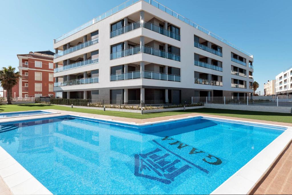 an apartment building with a swimming pool in front of it at Sunny Sea in La Mata