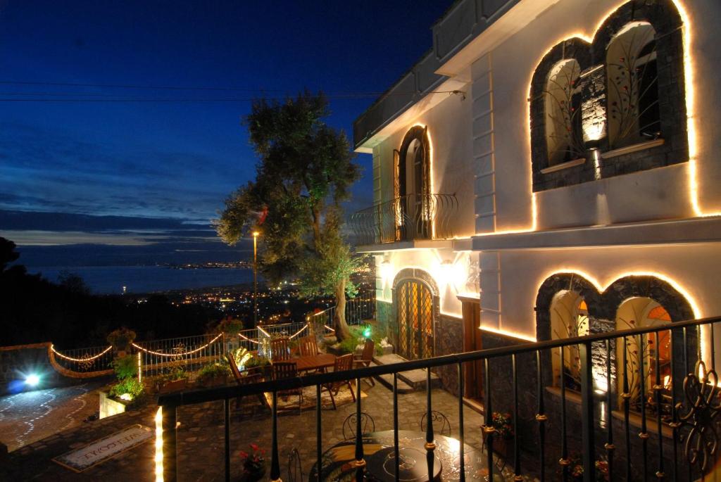 a building with a balcony at night with lights at La Dimora le Fumarole Rooms in Ercolano