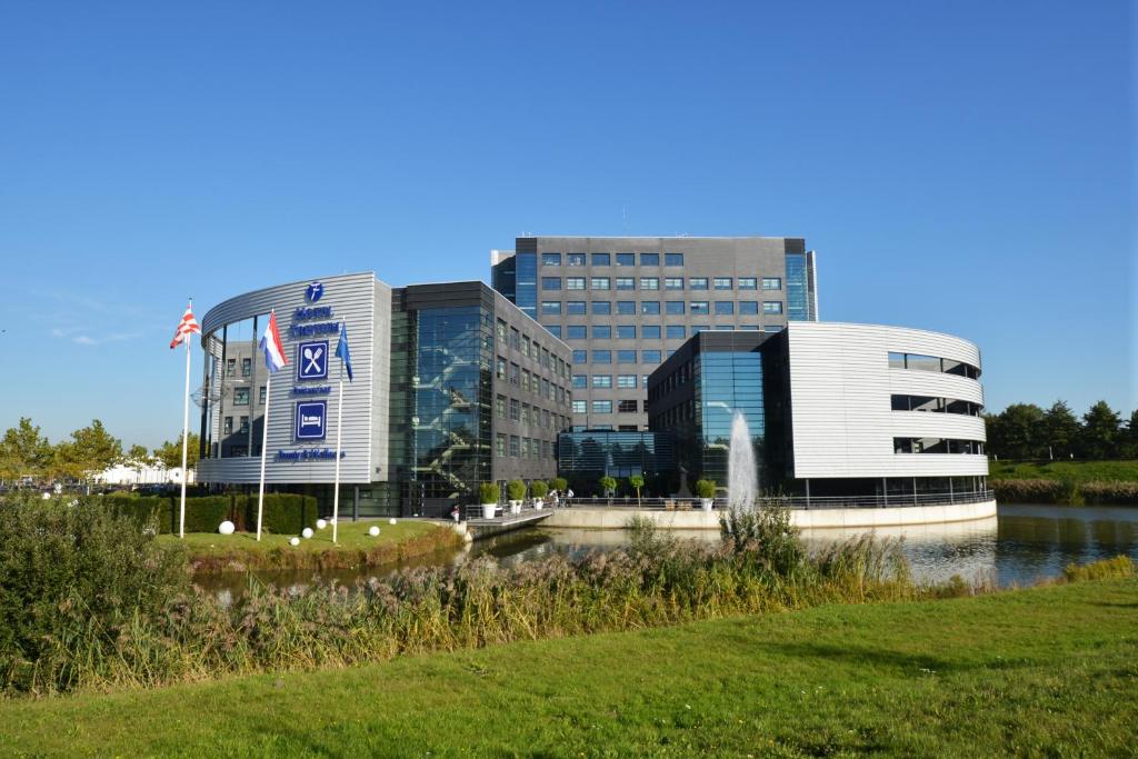 un bâtiment en face d'une masse d'eau dans l'établissement Fletcher Wellness-Hotel Trivium, à Etten-Leur