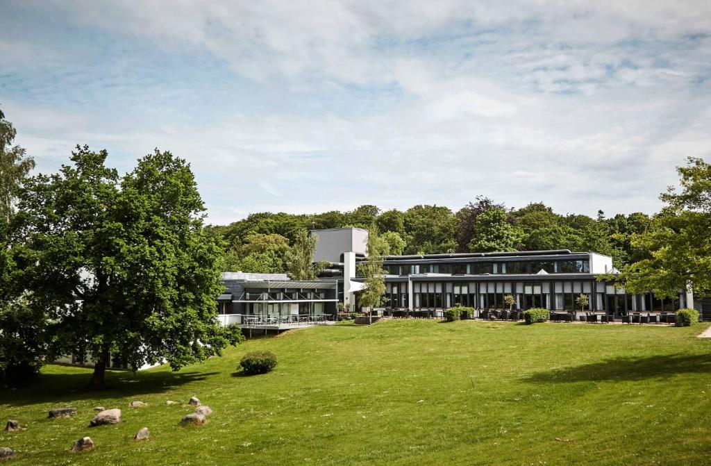 a building with sheep in the grass in front of it at Comwell Holte in Holte